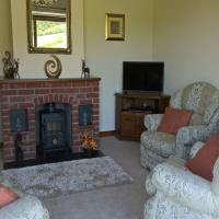 Lounge with woodburner, patio doors and beautiful views down the valley.