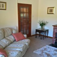 Comfy family lounge with wood burner and patio doors which open out onto the garden.